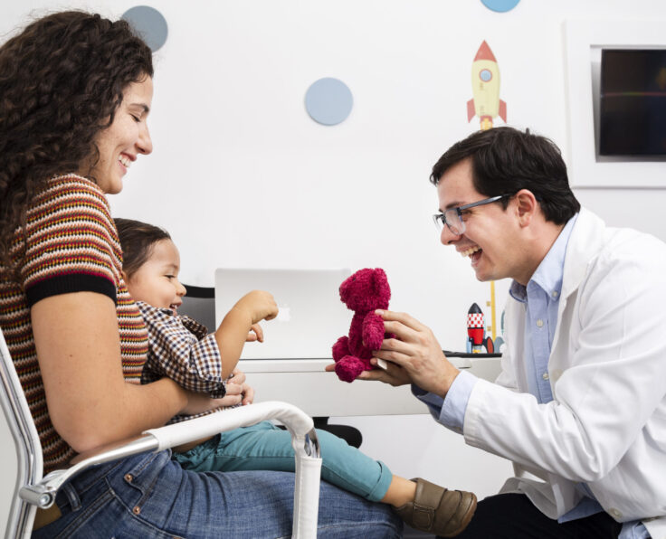 side-view-doctor-playing-with-baby-boy