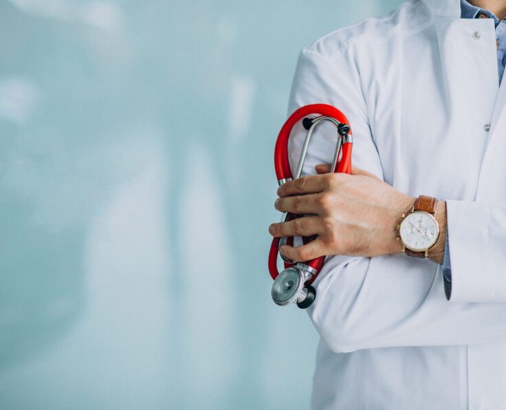 Young handsome physician in a medical robe with stethoscope